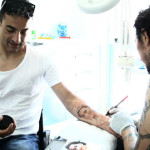 Andrea Quarta, marito di Lory, mentre fa continuare da Luca Natalini il tatuaggio iniziato dalla moglie (ritratto di Lory)